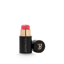 Cream blush stick in black tube with gold accents and pink balm, cap beside it