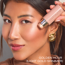 Light gold shimmer highlighter on cheek, makeup application close-up