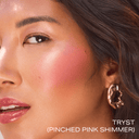 Pinched pink shimmer highlighter on cheek, face close-up