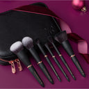 Set of makeup brushes with a black case on a purple background