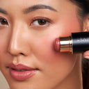 Model applying YB blush stick.